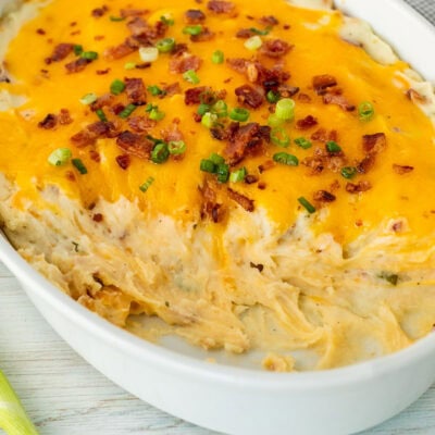 Casserole dish with scooped out areas from Loaded Mashed Potatoes.