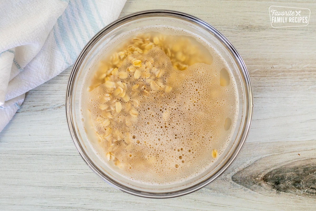 Glass bowl with oatmeal soaking in hot water.