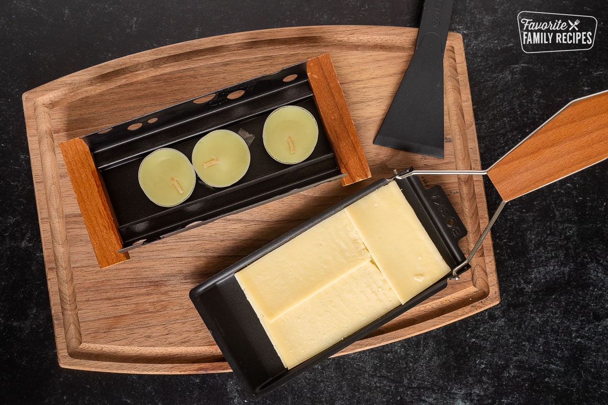 Raclette dish with raclette cheese slices and candles.