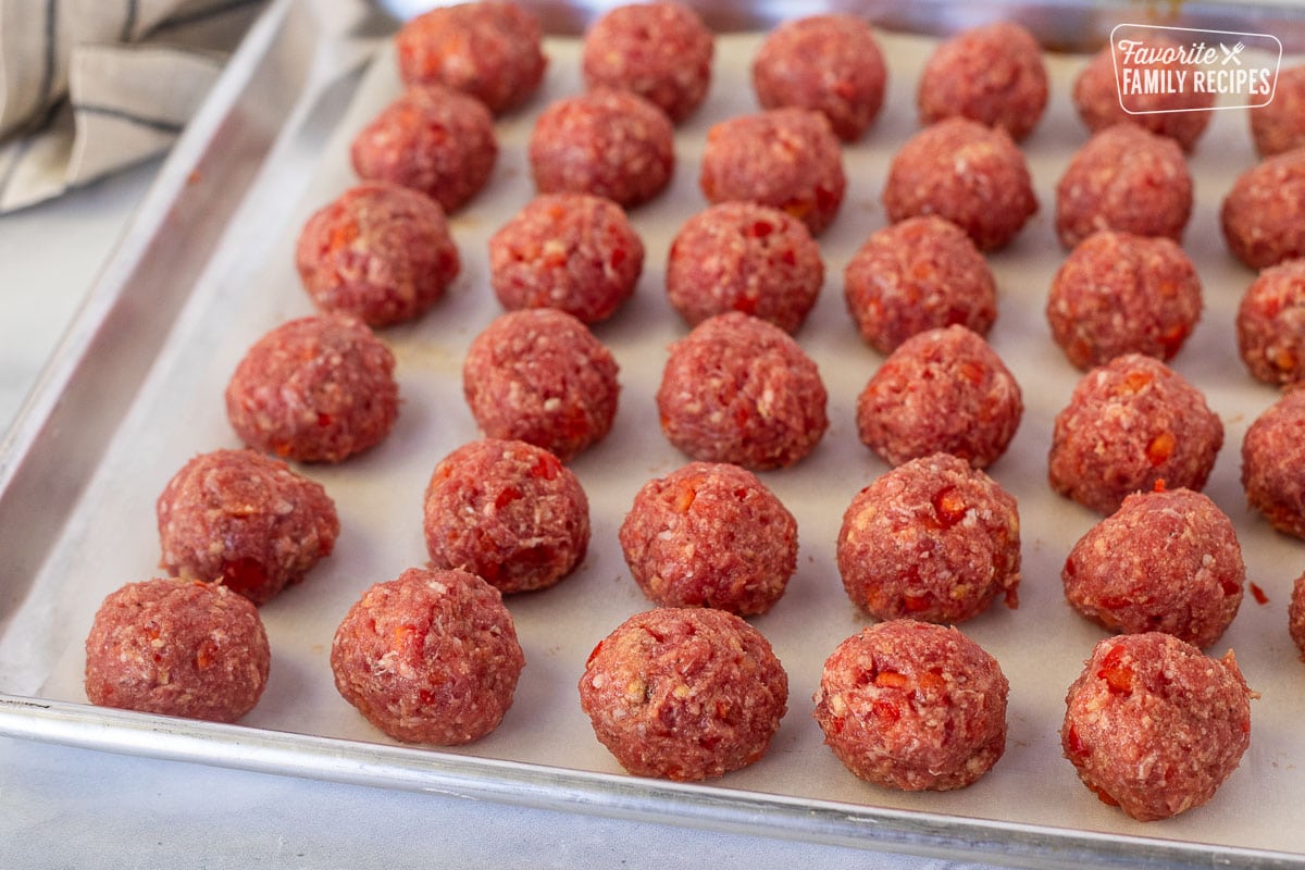 Meatballs on a baking sheet lined with parchment paper.