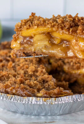 Hand holding a slice of Gluten Free Apple Pie over the pie.