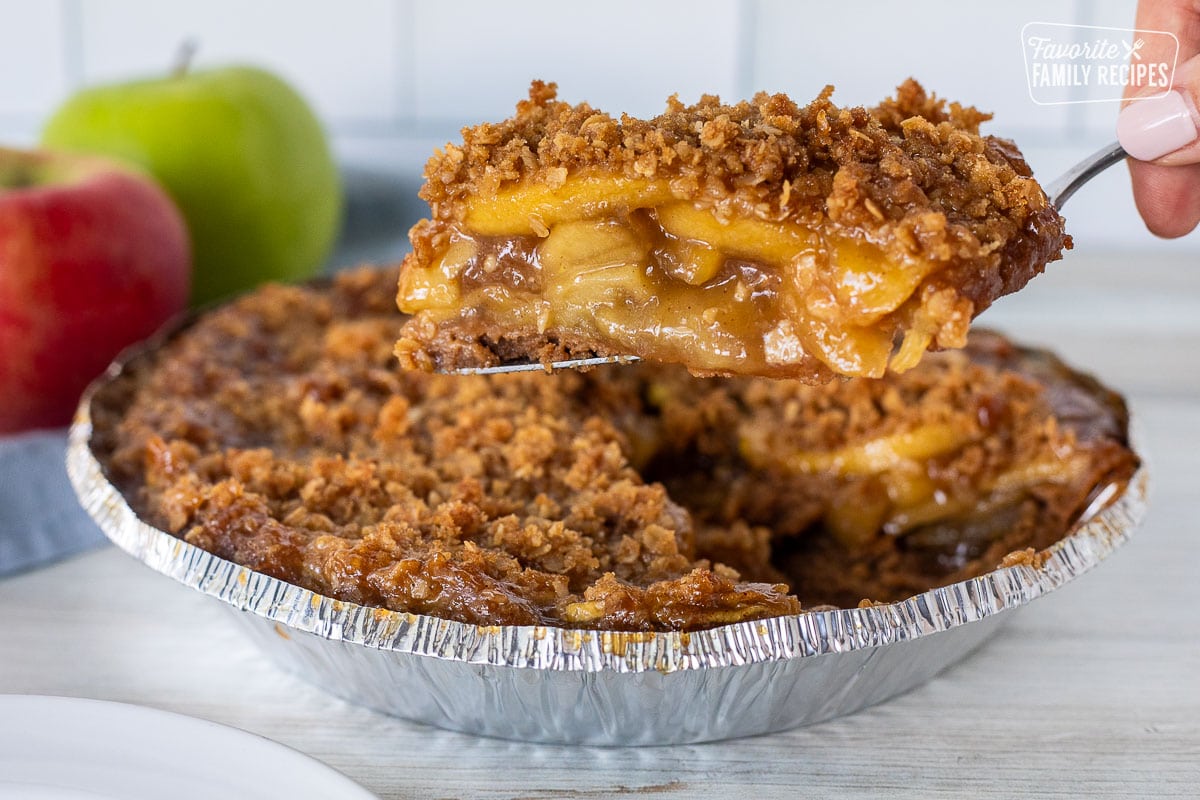 Hand holding a slice of Gluten Free Apple Pie over the pie.