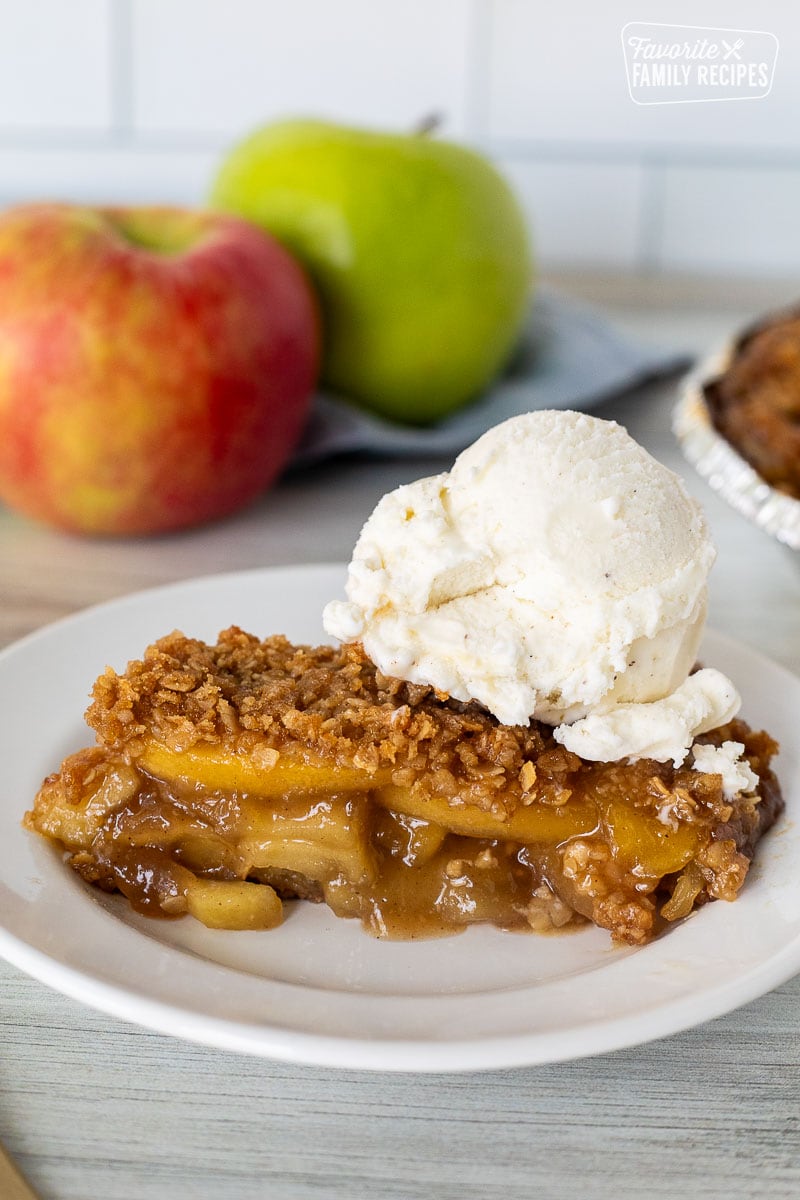 Slice of Gluten Free Apple Pie on a plate with a large scoop of vanilla ice cream on top.