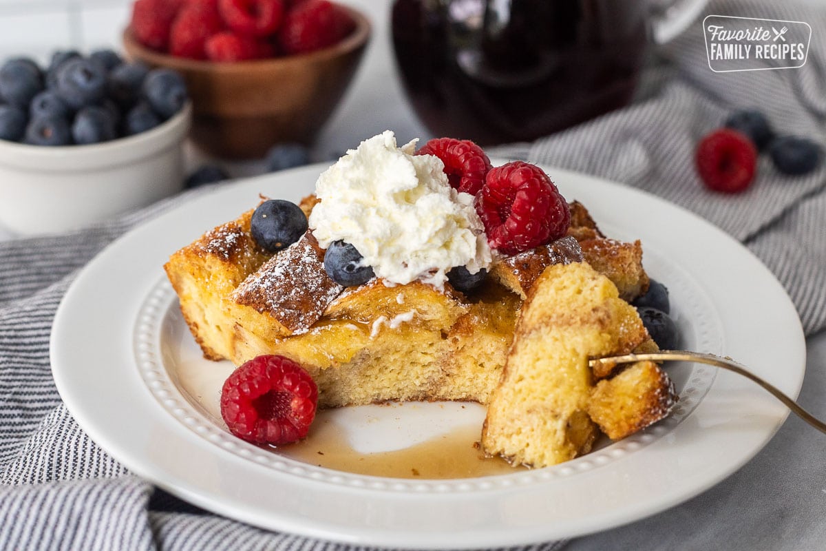 Brioche French toast casserole slice on a plate with a fork cut into.