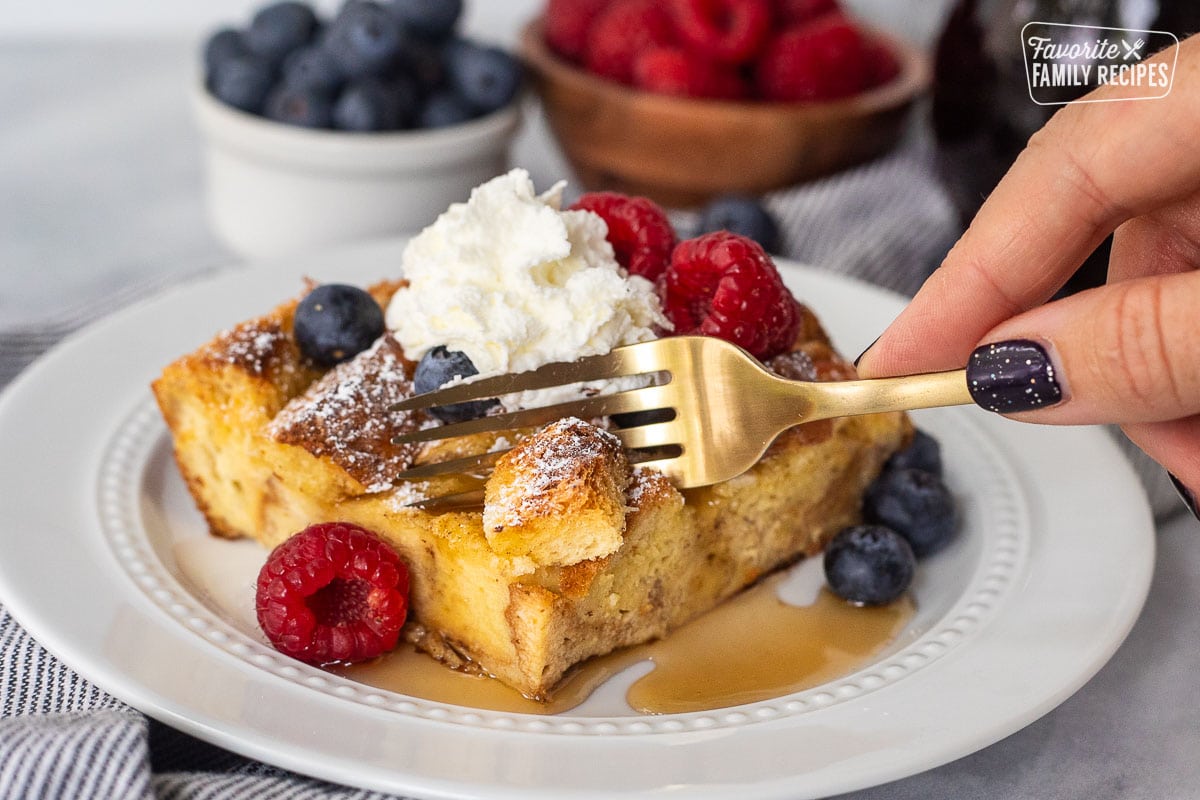 Fork cutting into a slice of brioche French toast casserole.