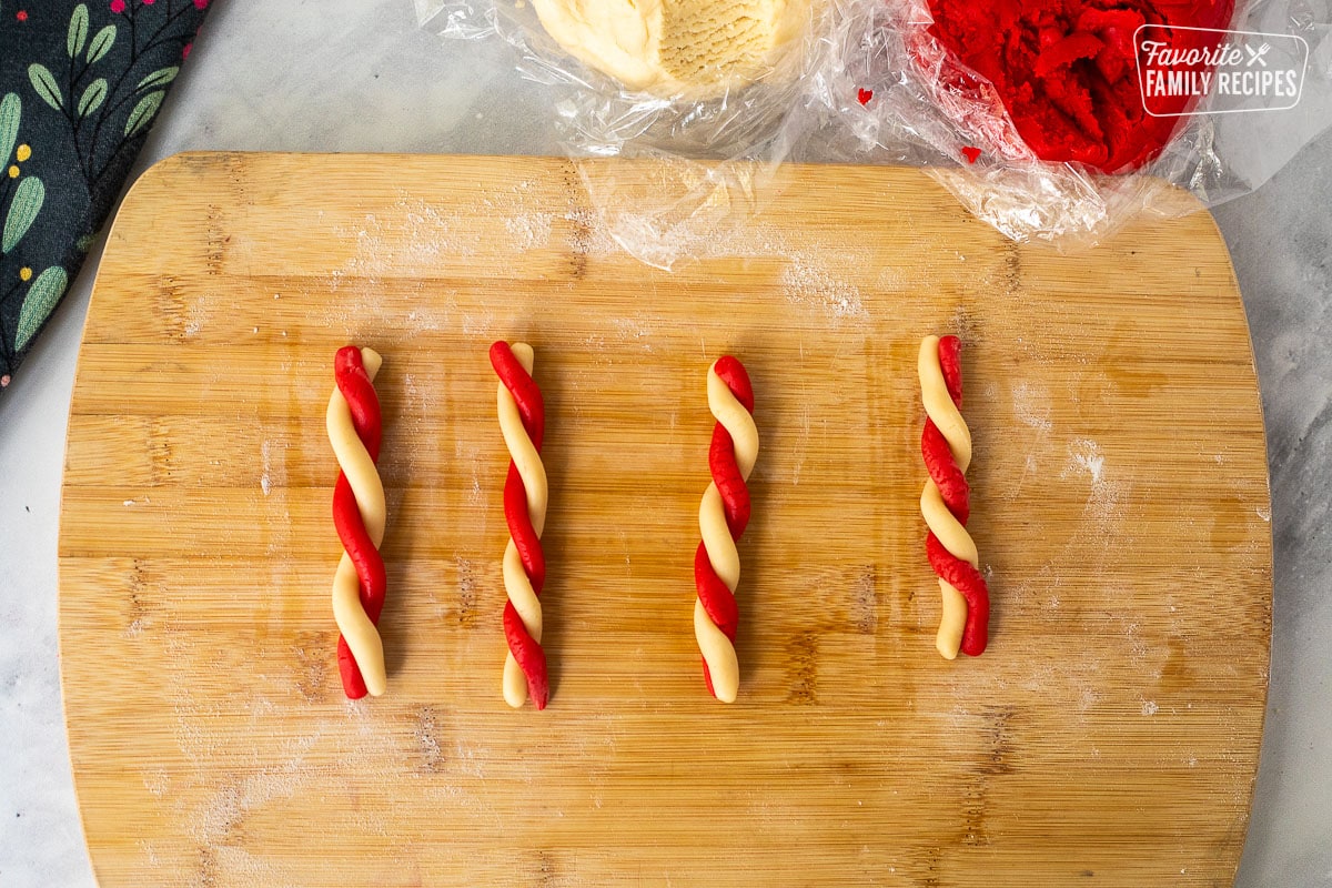 Twisted, red and white cookie dough on a floured board.