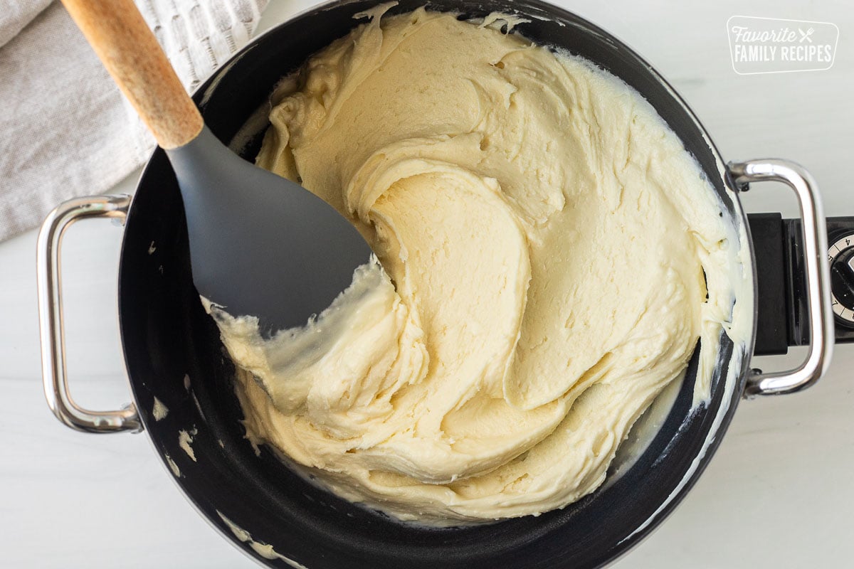 Melted white chocolate chips in fondue pot.