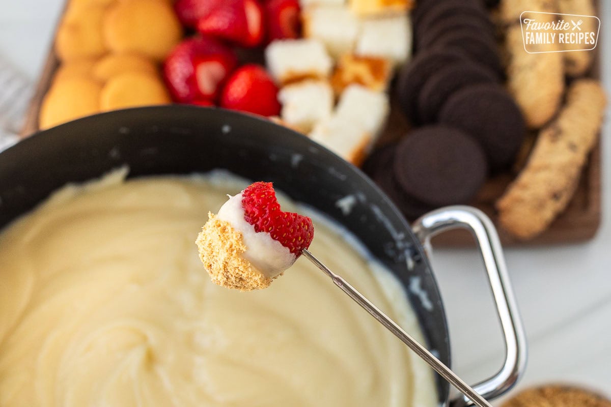 Strawberry on a skewer dipped in Cheesecake Fondue.