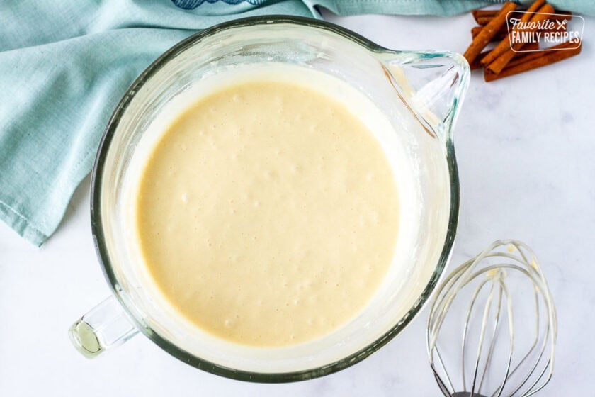 Glass mixing bowl with cake batter. Mixing whisk on the side.