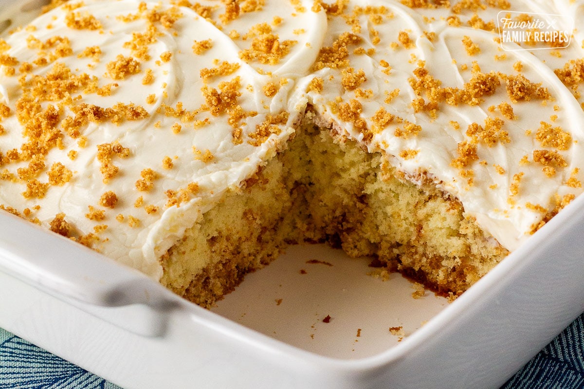 Cinnamon roll cake in a baking dish missing a slice.