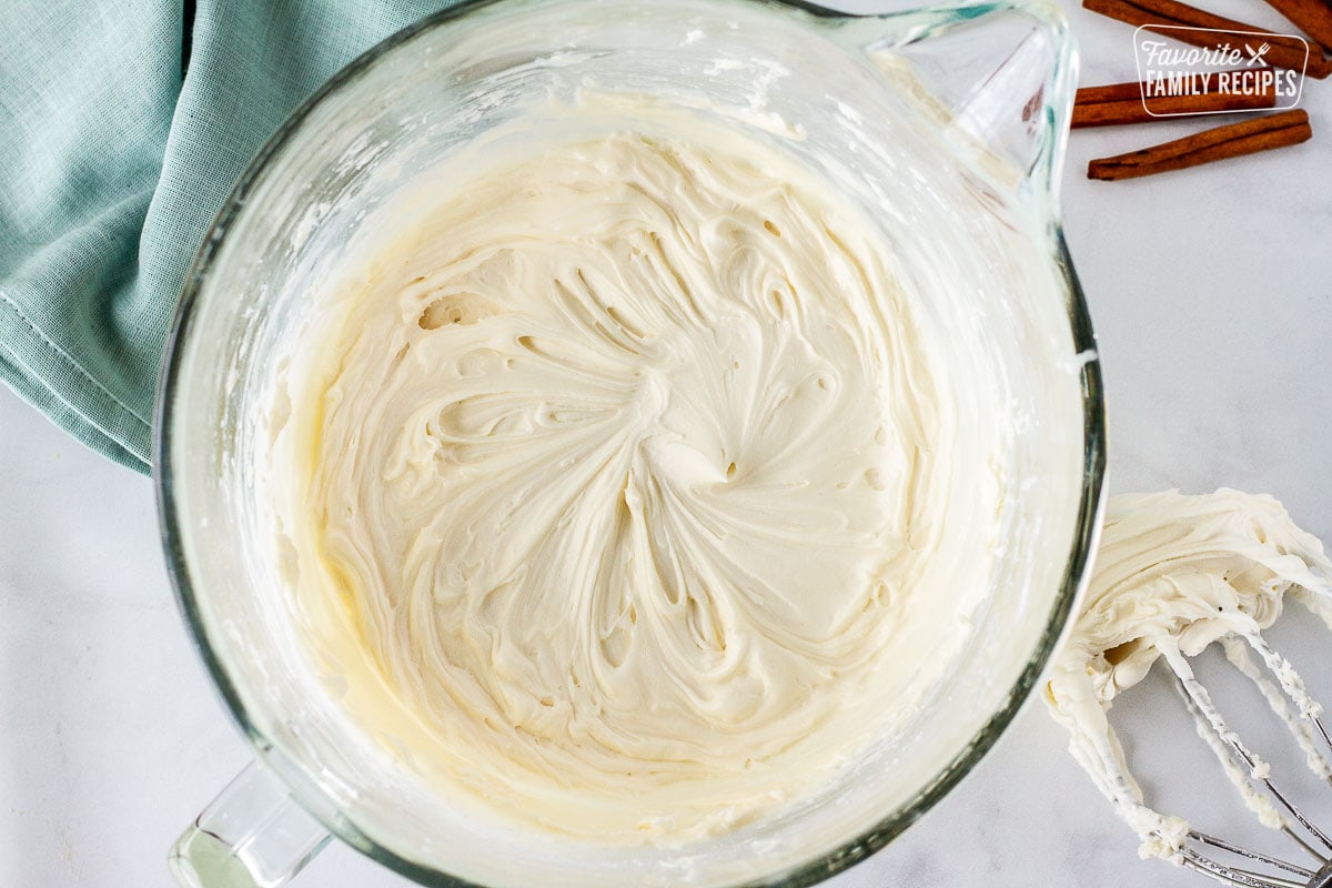 Glass mixing bowl with frosting. Whisk on the side.