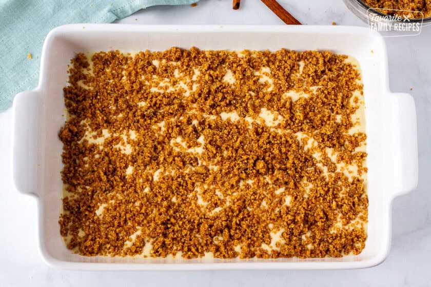 Baking dish with cake batter and cinnamon crumble on top.