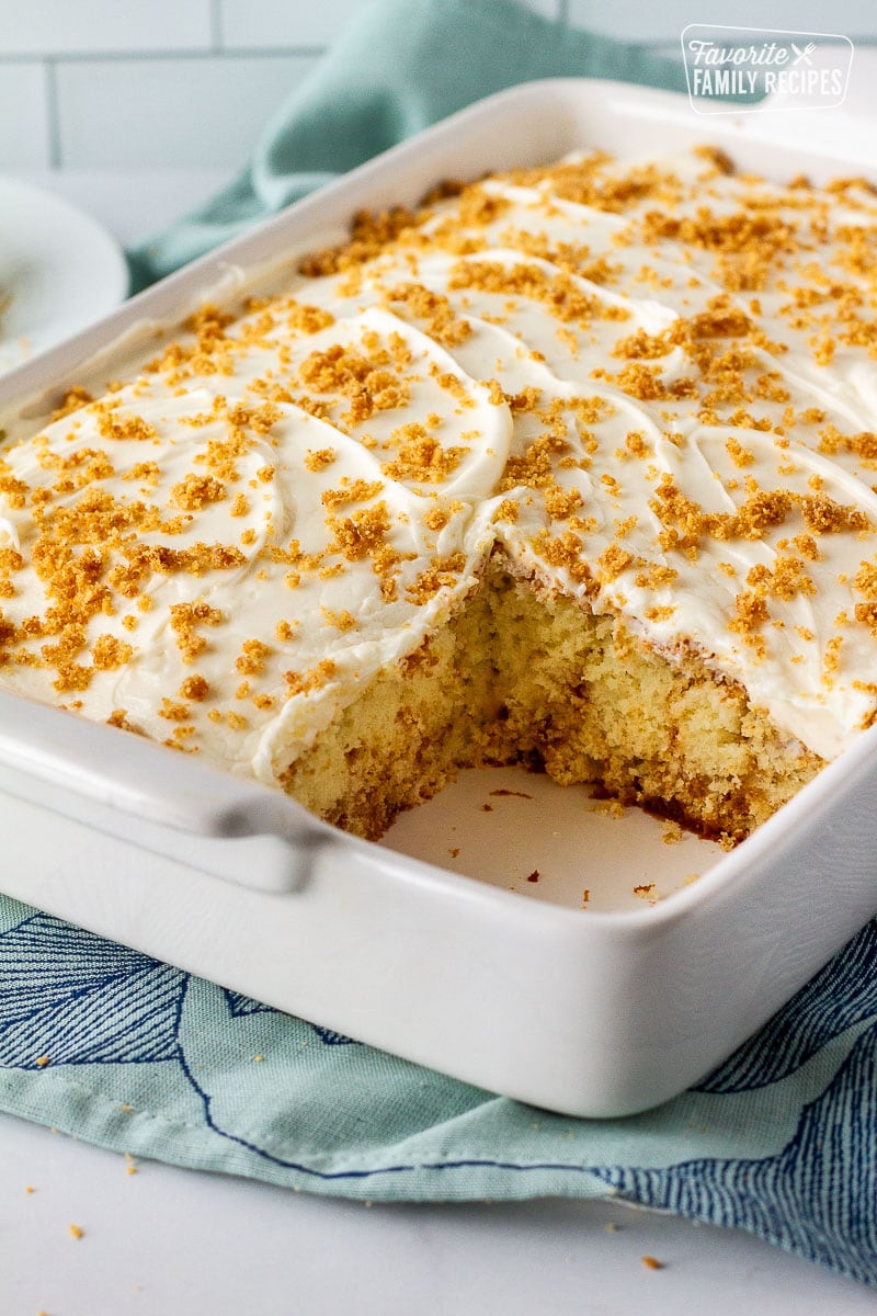 Cinnamon roll cake in a baking dish missing a slice.