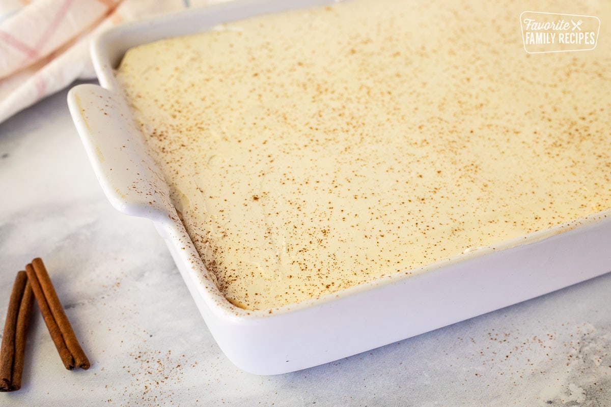 Cinnamon sprinkled on top of Pumpkin Eclair Cake in a baking dish.