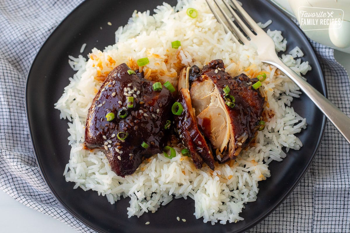 Crockpot Hawaiian chicken over rice on a plate with a fork.