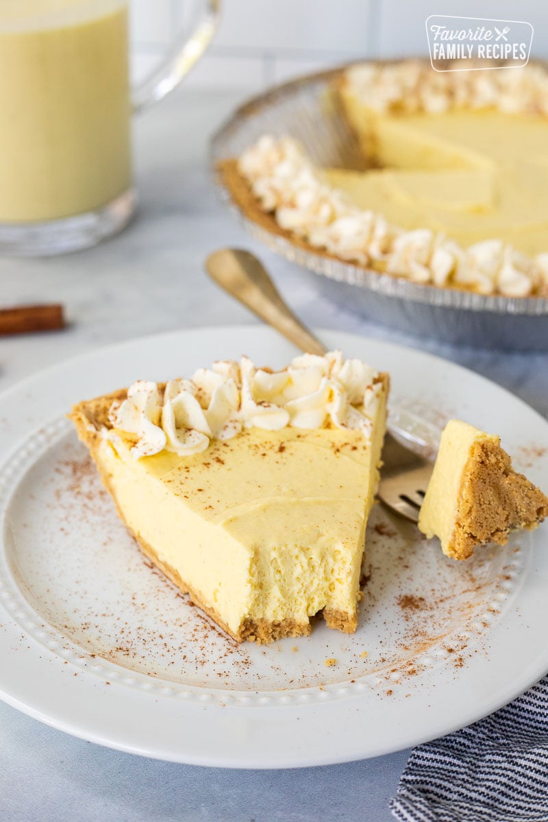 Egg nog pie slice on a plate with a fork cut into the piece of pie.