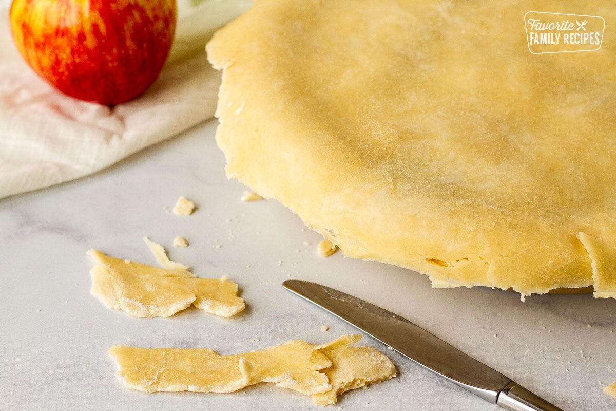 Butter knife cutting excess Apple Pie dough.