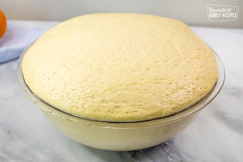 Glass bowl with risen bread dough.