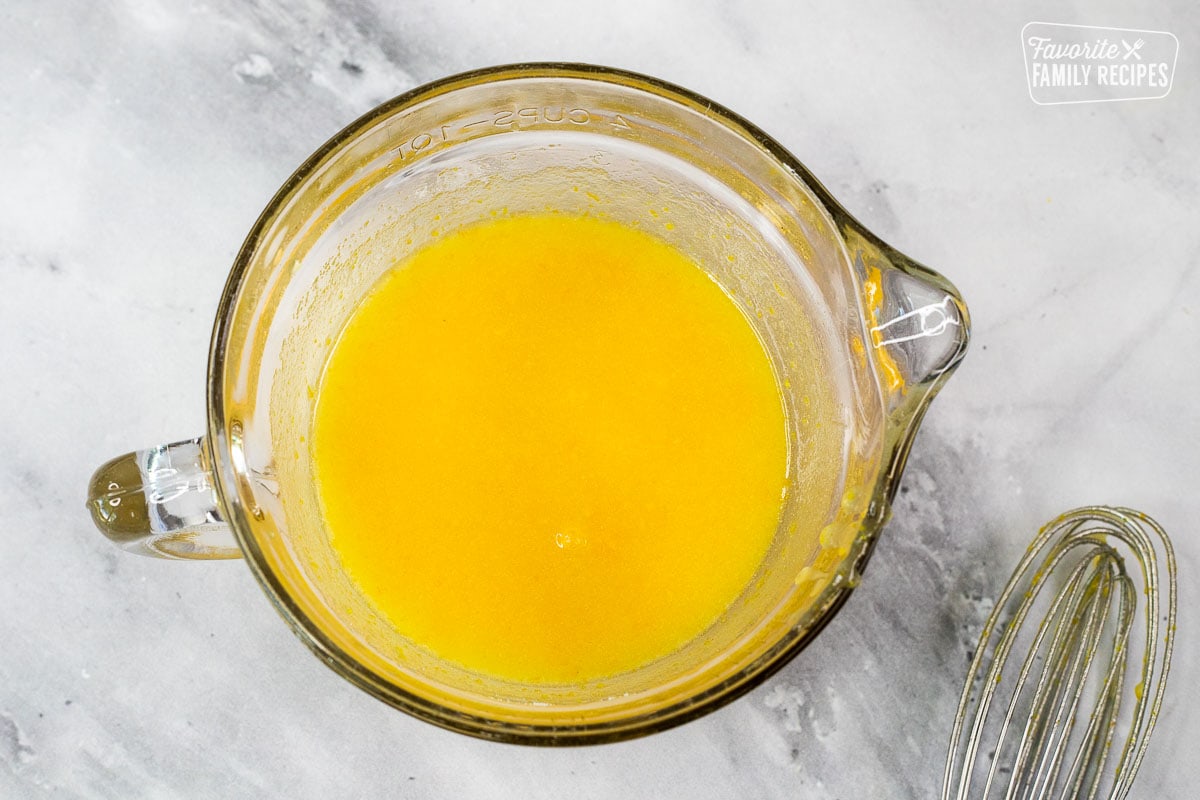 Glass with orange zest, orange juice, and butter mixture.