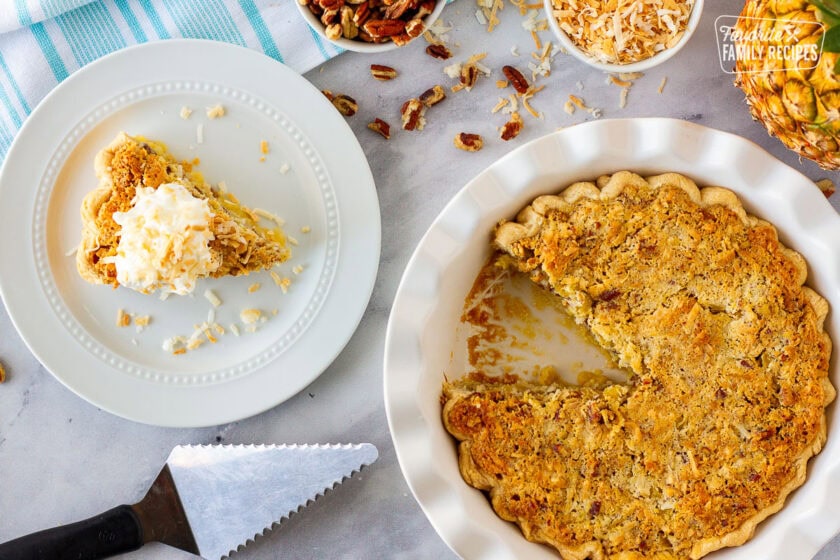 Island pecan pie in a dish next to a slice of pie on a plate.