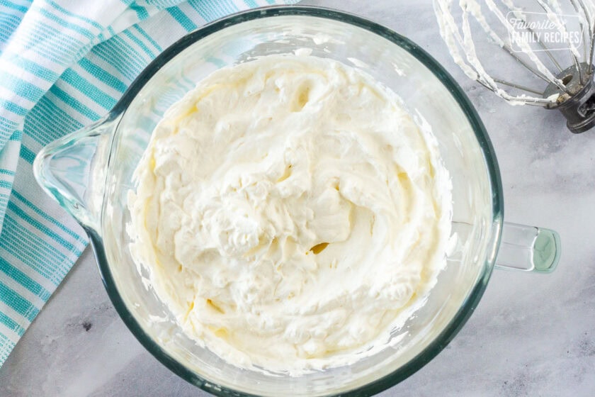 Mixing bowl with whipped topping. Whisk on the side.