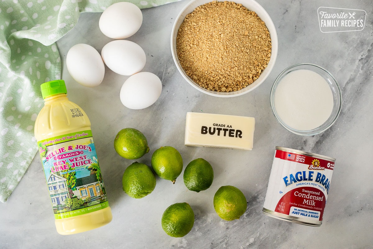 Ingredients to make Key lime pie, including sweetened condensed milk, sugar, crushed graham crackers, butter, eggs, and Key West lime juice.