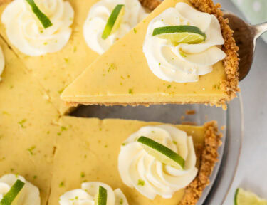 Slice of key lime pie on a pie spatula, lifting from the pie dish.