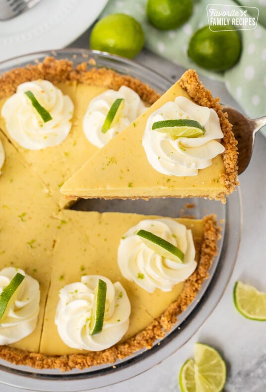 Slice of key lime pie on a pie spatula, lifting from the pie dish.