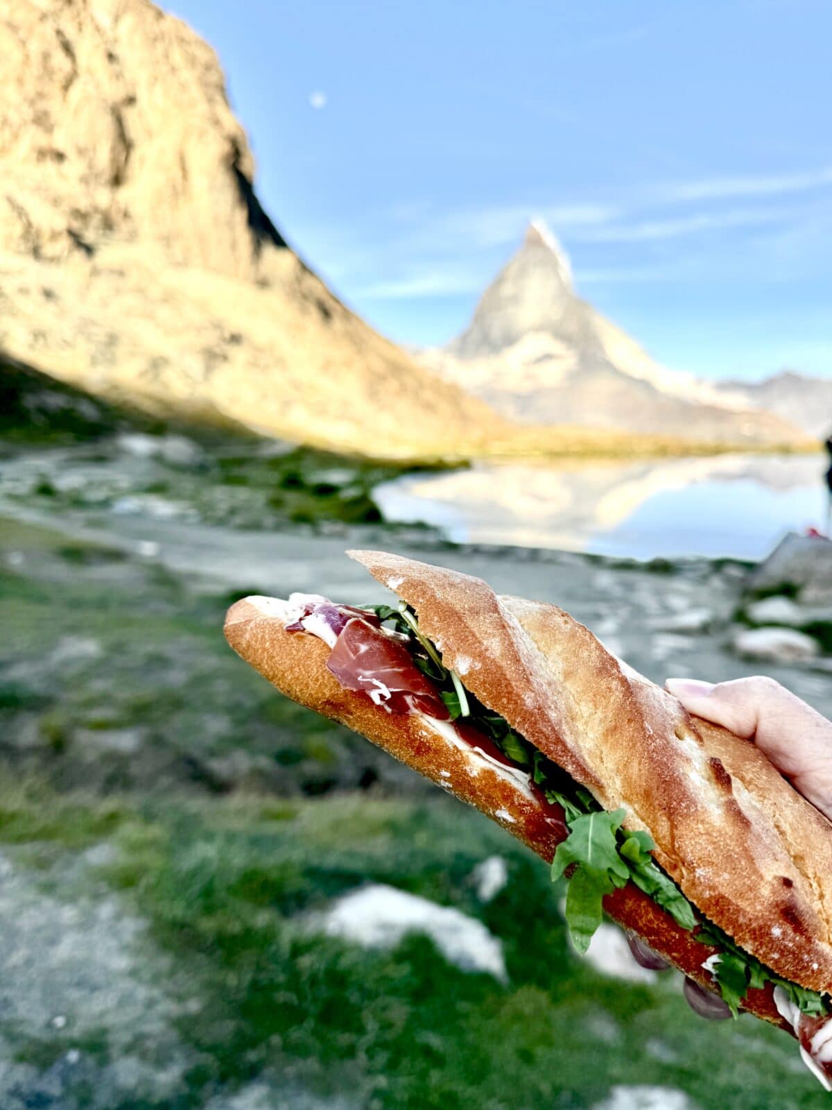 Swiss sandwich being held up in front of the Matterhorn