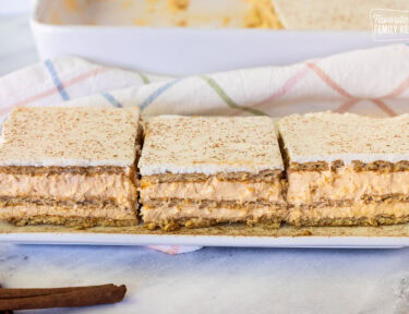 Three slices of Pumpkin Eclair Cake lined up on a plate.