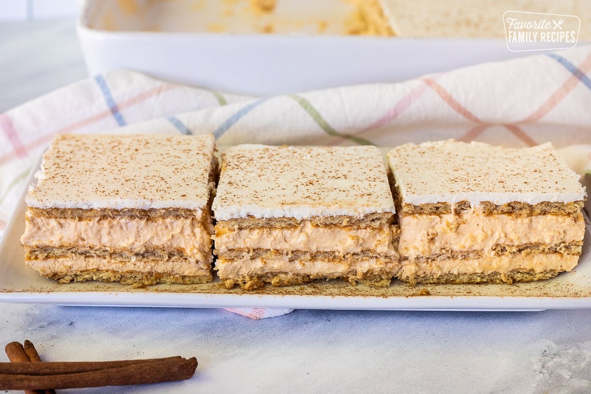 Three slices of Pumpkin Eclair Cake lined up on a plate.