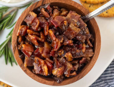 Bacon jam in a wooden bowl with a spoon.