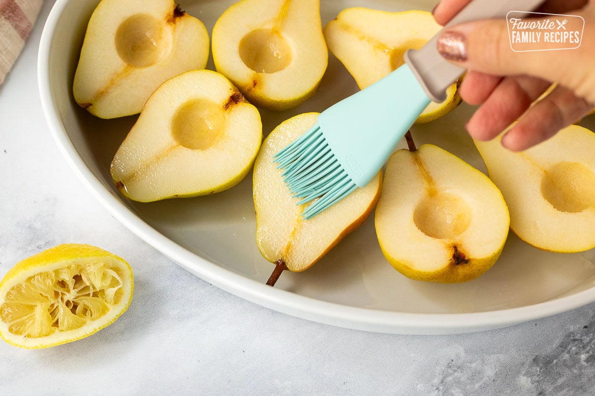 Spreading lemon juice on sliced pears.