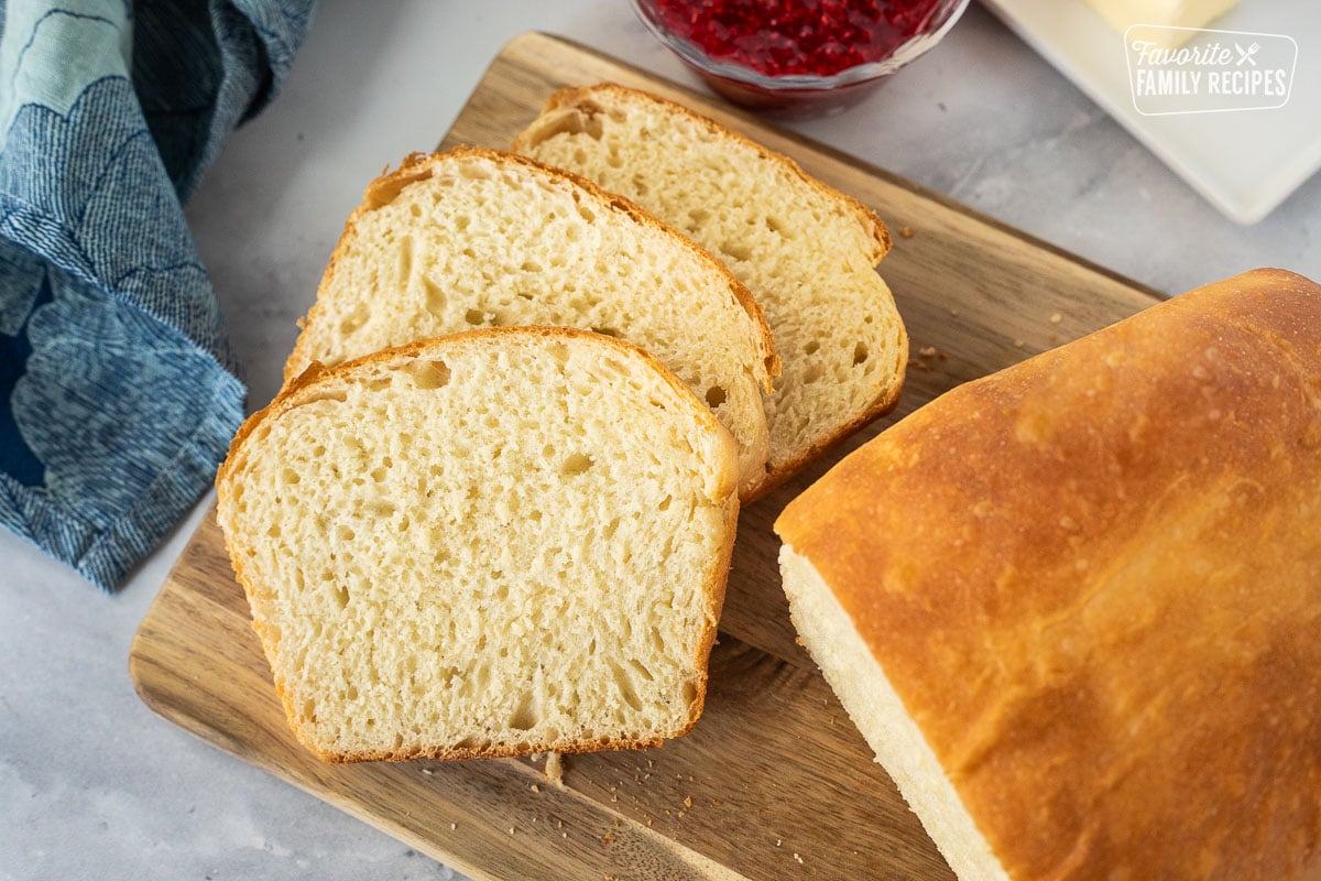 Sliced loaf of baked bread on a cutting board.