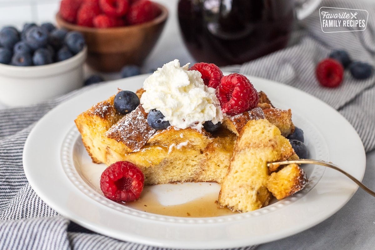 Brioche French toast casserole slice on a plate with a fork cut corner.