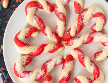 Plate of candy cane cookies with crushed candy canes in a bowl on the side