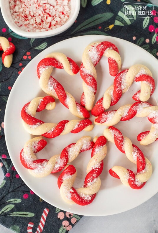 Plate of candy cane cookies with crushed candy canes in a bowl on the side