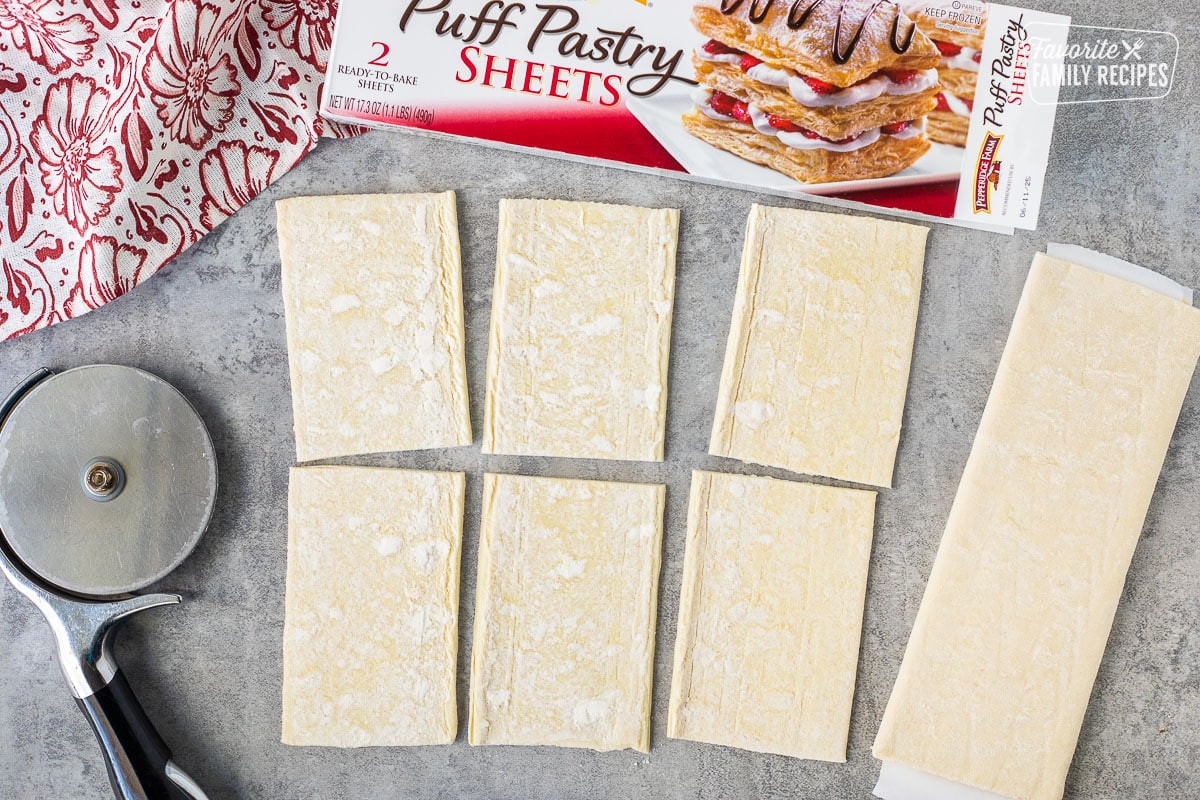 Rolled out, puff pastry sheet cut into six rectangles with a pizza slicer.