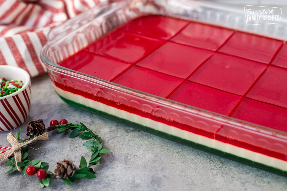 Sliced Christmas Jell-O salad in a glass dish.