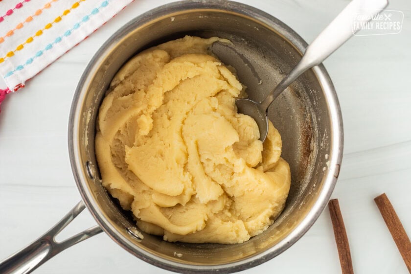 Sauce pan with waffle batter and spoon.