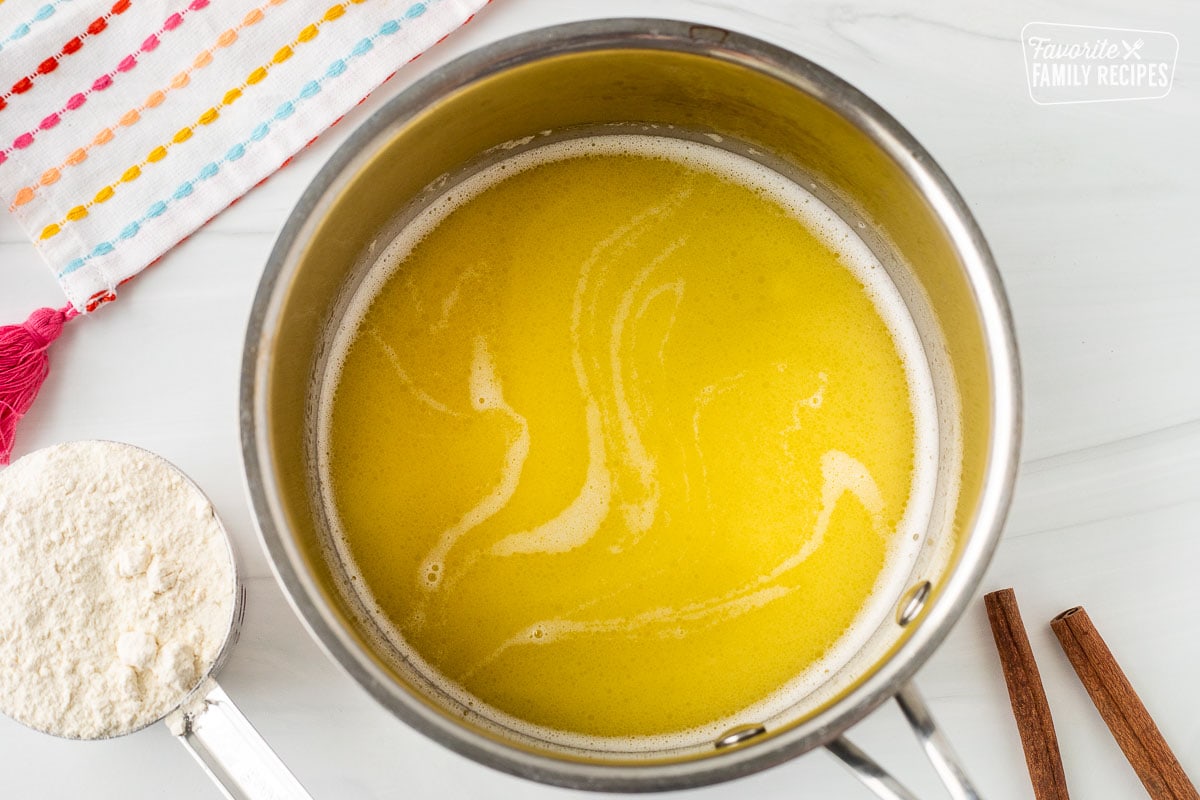 Sauce pan with melted butter. Cup of flour on the side.