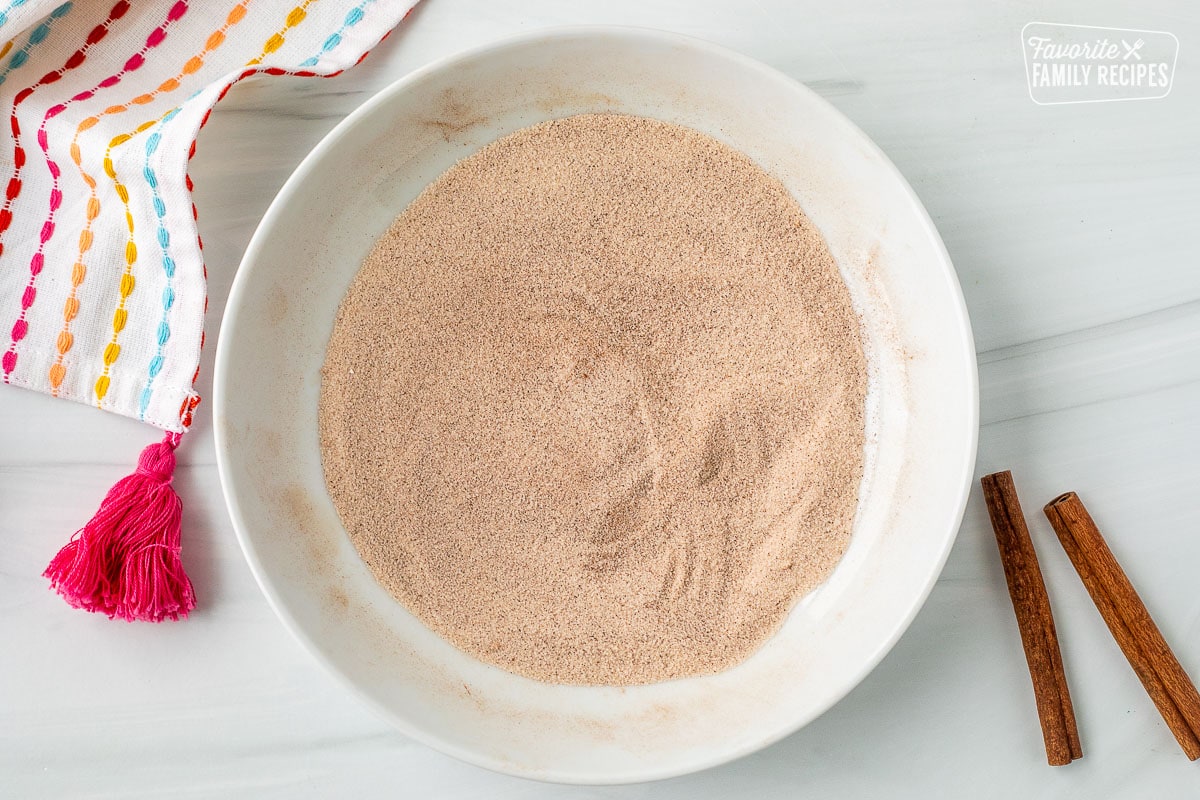 Glass bowl with combined cinnamon and sugar.