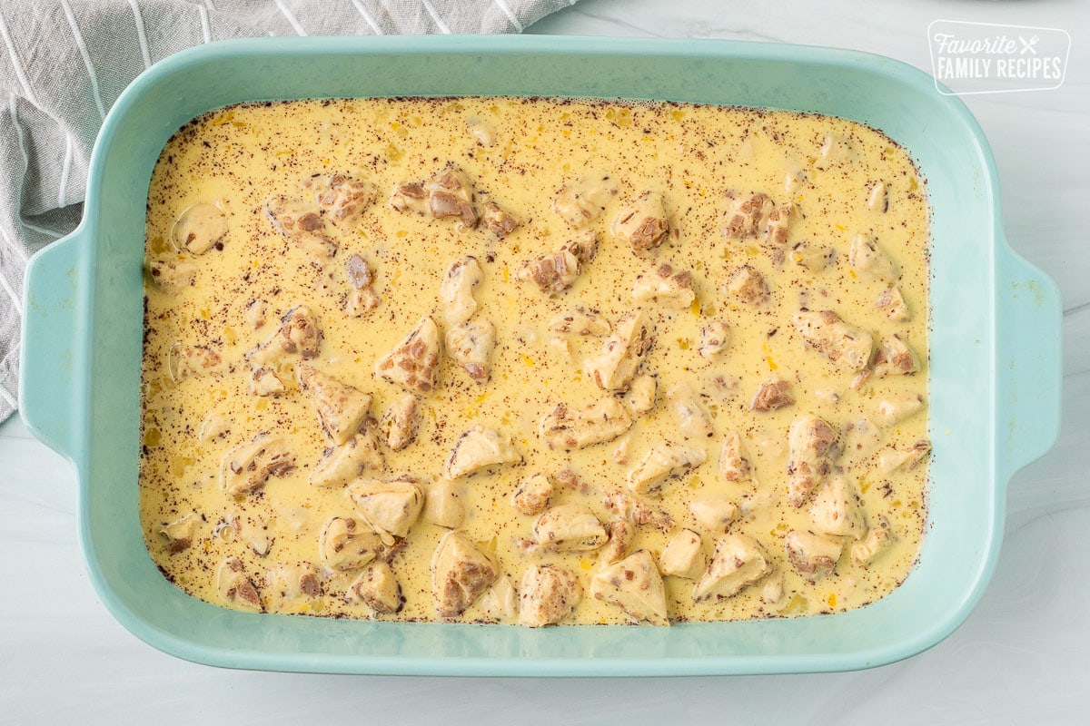 Eggs poured over cinnamon rolls in a baking dish.