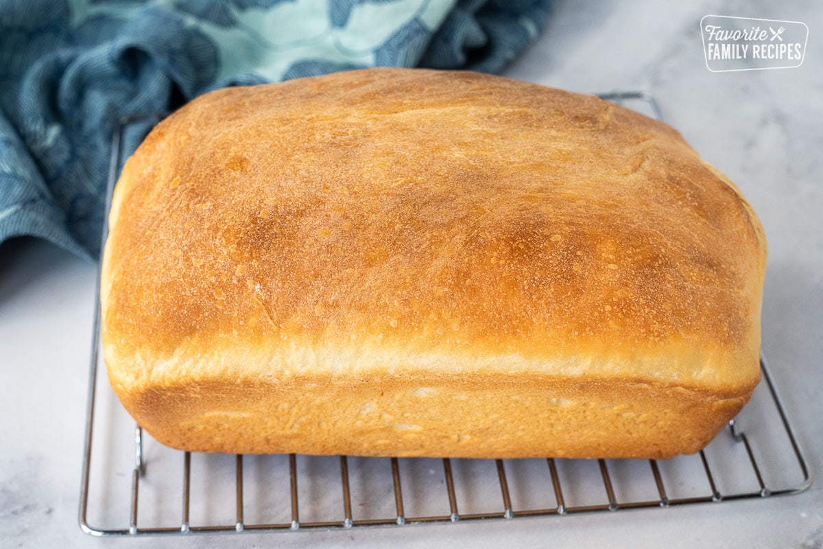 Baked bread loaf on a cooling rack.