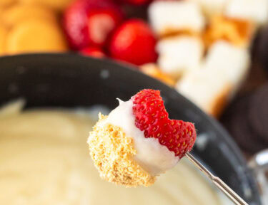 Strawberry on a skewer dipped in Cheesecake Fondue.