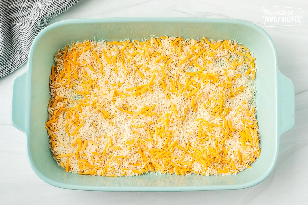 Cheese and uncooked rice in a casserole dish.