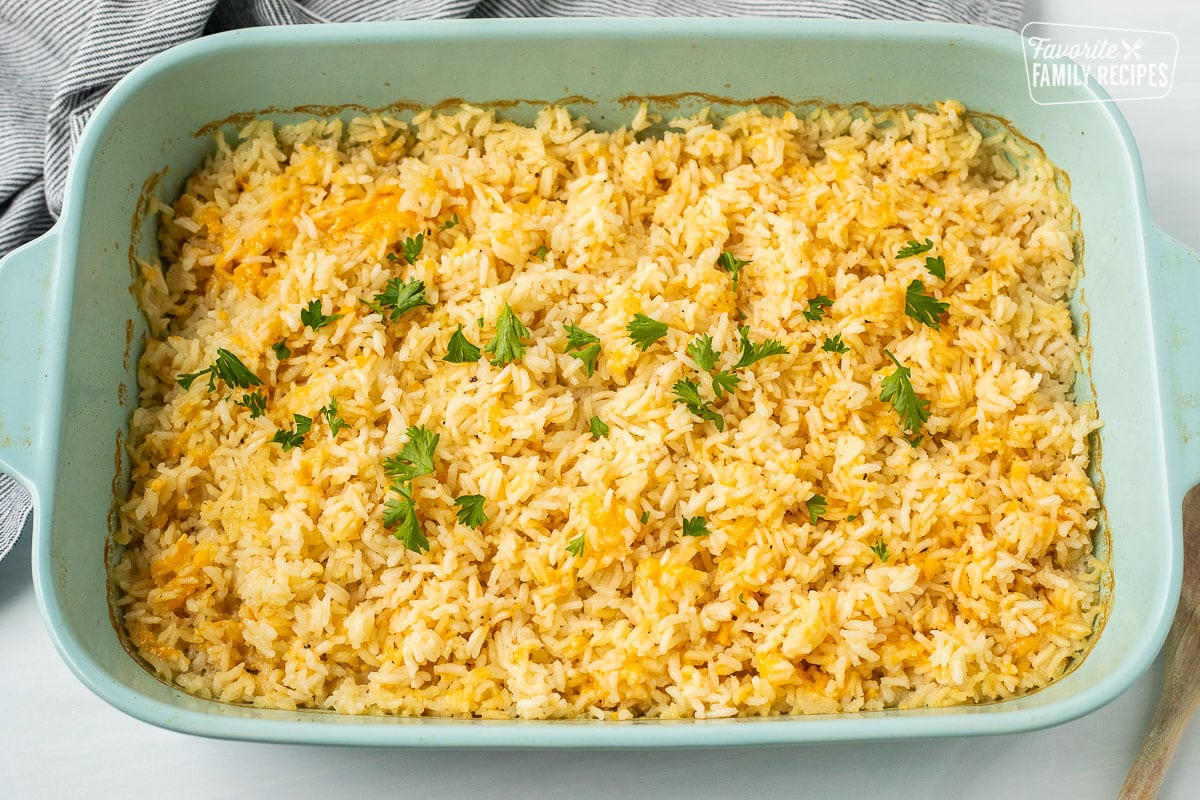 Casserole dish of cheesy rice with parsley.