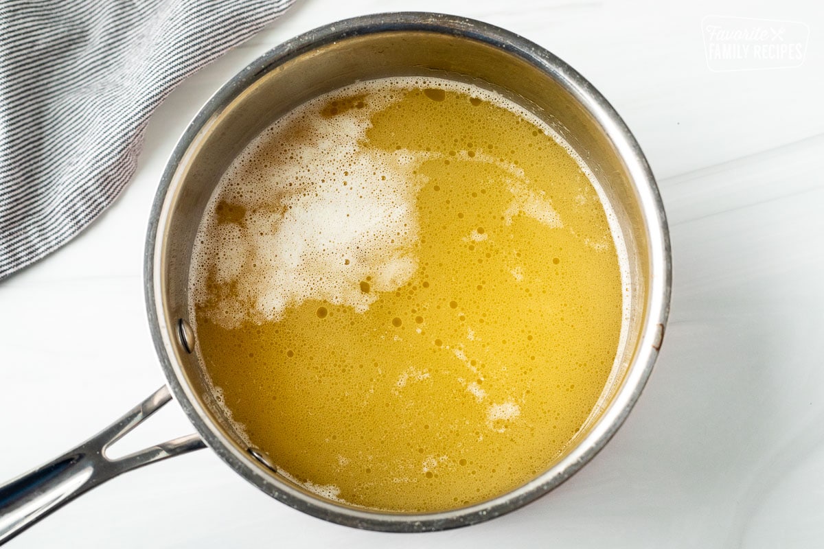 Saucepan with boiling chicken broth and butter.