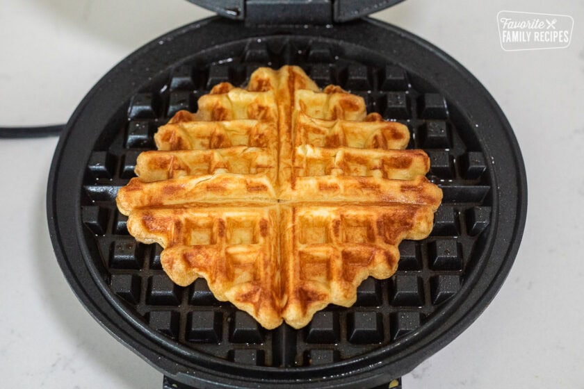 Baked waffle in a waffle iron.