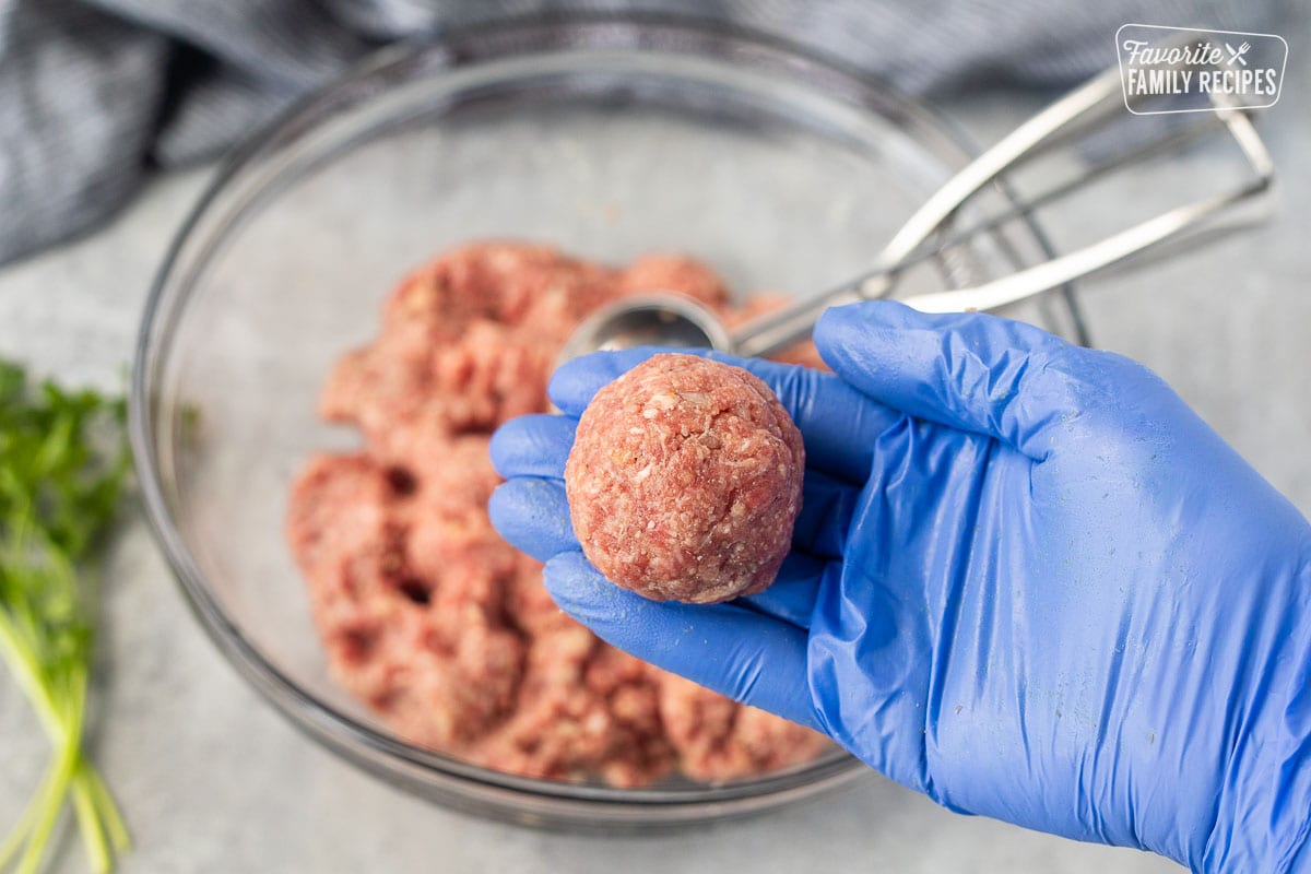 Holding up a shaped meatball.